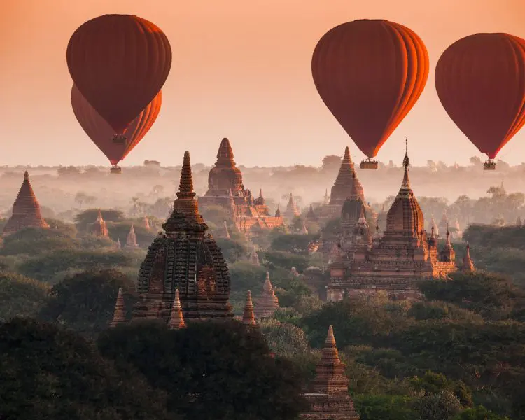 hot air balloons over a Asian temples