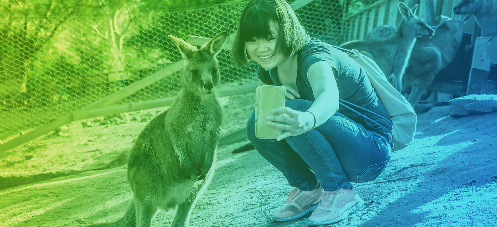 A woman taking a selfie with a baby kangaroo