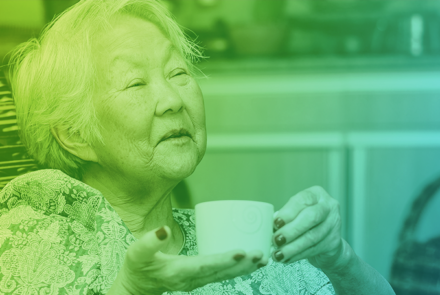 An image of an elderly Japanese woman drinking a cup of tea
