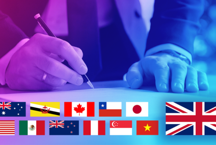 An image showing a person signing a document with world flags underneath