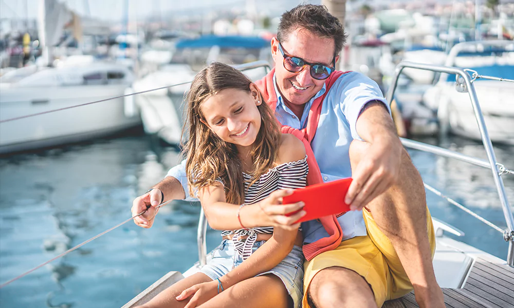 father and daughter taking a selfie on a boat