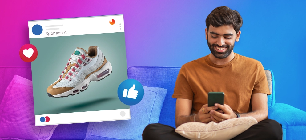 A man looking at his phone with an example of Facebook ad next to him