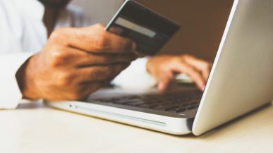 A man checking his credit card number for an online order