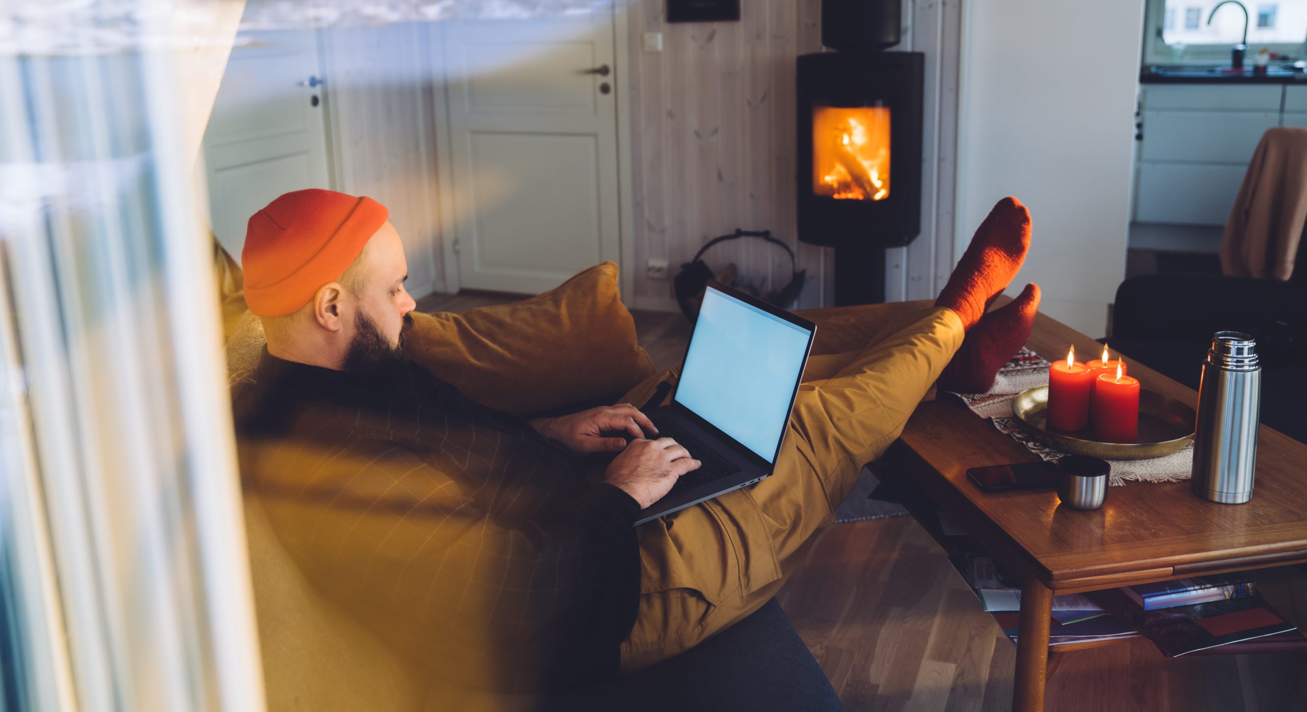 Man with feet up on coffee table and laptop on his lap