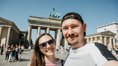 Two tourists taking a selfie infront of the Brandenburg Gate