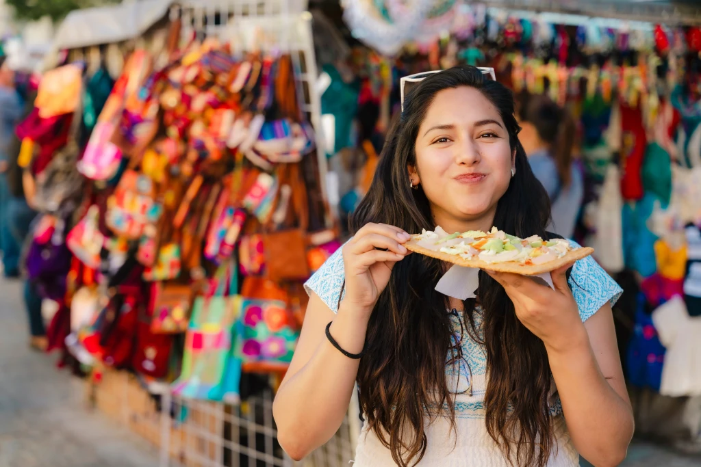 A woman at a market eating chicharron preparado