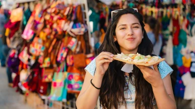 A woman at a market eating chicharron preparado