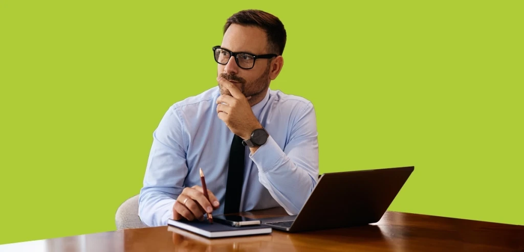 A businessman thinking whilst using a laptop