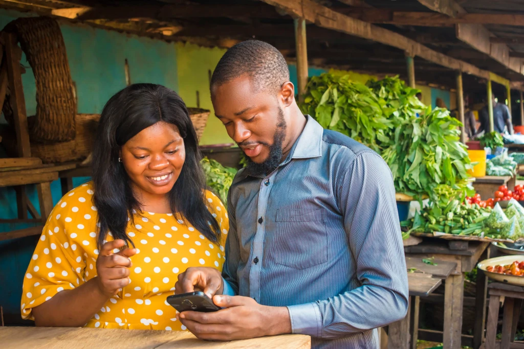 A Nigerian man and woman looking at a phone