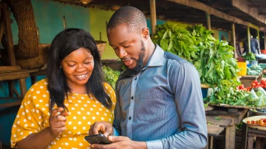 A Nigerian man and woman looking at a phone
