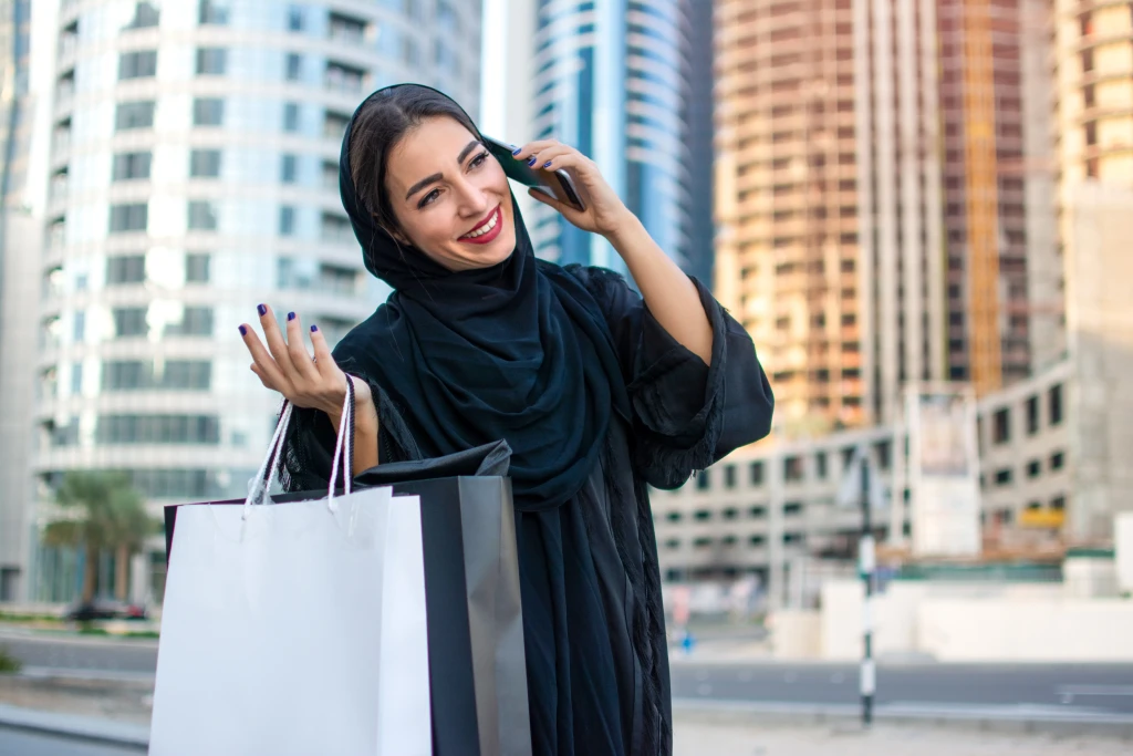 A Muslim woman chatting on the phone wearing an Abaya