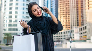 A Muslim woman chatting on the phone wearing an Abaya