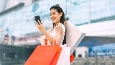 A Thai woman checking her phone whilst shopping