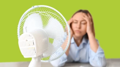A businesswoman cooling off in front of an electric fan